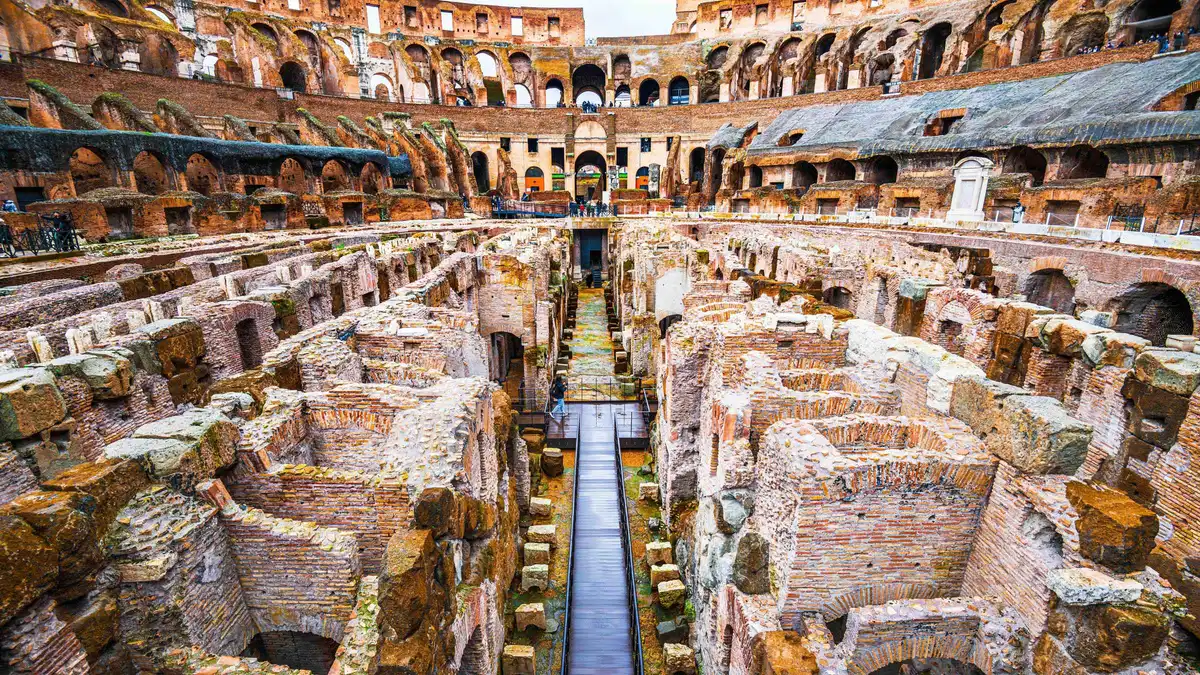 Guide explaining the Colosseum underground levels to a small group on a Rome underground tour